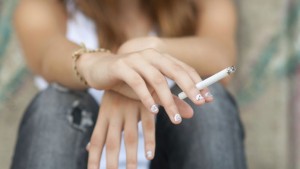 Teenage hands holding cigarette